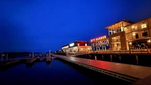 A waterfront hotel with a dock extending into calm waters, featuring a prominent 'City Harbor' sign. - Fishing Cabin Getaway (Grant)