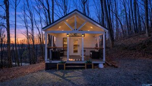 A small cabin with a porch, a door, and two windows. - Waterfront Boat Ramp Getaway (Grant)