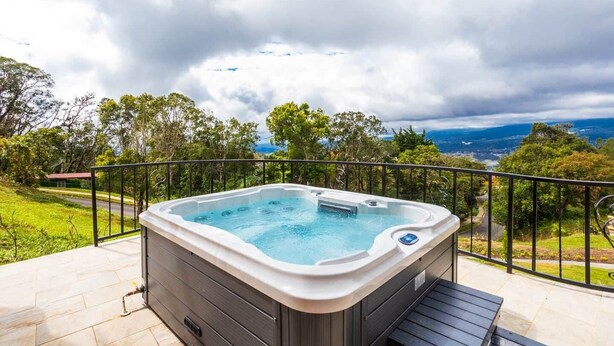 A hot tub on a balcony with a view of a road and trees. - House in Boquete, House in Boquete with king beds and hot tub (565749) (Alto Jaramillo)