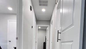 A hallway with white doors, a wooden floor, and recessed ceiling lights. - A Home Stay on Business Trip - Near Airport (Atlanta)