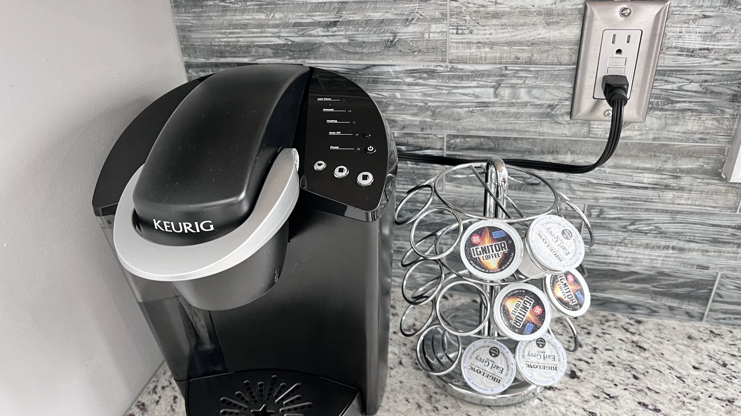 Eine Kaffeemaschine von Keurig mit Wasserbehälter und einer Kapselhalterung für verschiedene Kapselmarken.