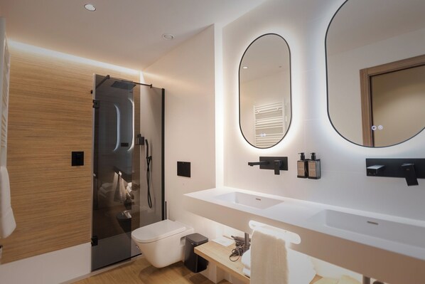 A modern bathroom with a glass shower enclosure, a large mirror, and a white sink.