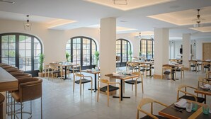 Un comedor amplio con techos altos, ventanas grandes y mobiliario moderno.