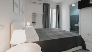 A modern bedroom with a bed, bedside lamps, a wardrobe, and a TV mounted on the wall. - Art Home Collection by Wonderful Italy - Pop Studio (Cefalù)