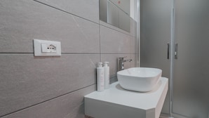 A modern bathroom with a white sink, two bottles of shampoo, and a shower. - Art Home Collection by Wonderful Italy - Pop Studio (Cefalù)