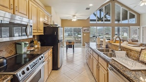 A spacious kitchen with modern appliances, large windows, and a view of the outdoors. - Stunning Lake Home Get Away on The Water! (Gun Barrel City)