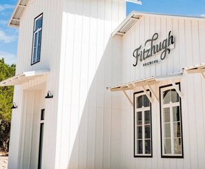 A white building with the sign "Fitzhugh Brewing" on the side.