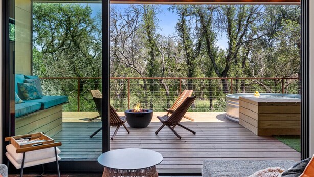 Une terrasse avec un foyer, des sièges et un jacuzzi.