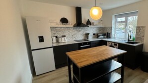 Uma cozinha moderna com mesa de madeira, armários pretos e uma janela que oferece luz natural.