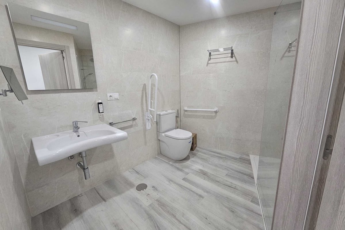 A modern bathroom with a sink, toilet, and shower area.
