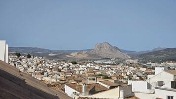 Un pueblo con una colina destacada al fondo.