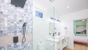A modern bathroom with a shower, a toilet, and a sink.