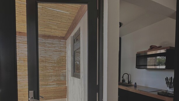 A modern kitchen with a wooden countertop, a built-in oven, and a small window above the sink. - Oceanfront Balcony King Bed suite steps to city center and beach Sunsets walks (Hatillo)