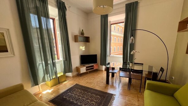 Un salon comprenant un canapé, une table basse, un téléviseur et un coin repas avec des chaises et une table.
