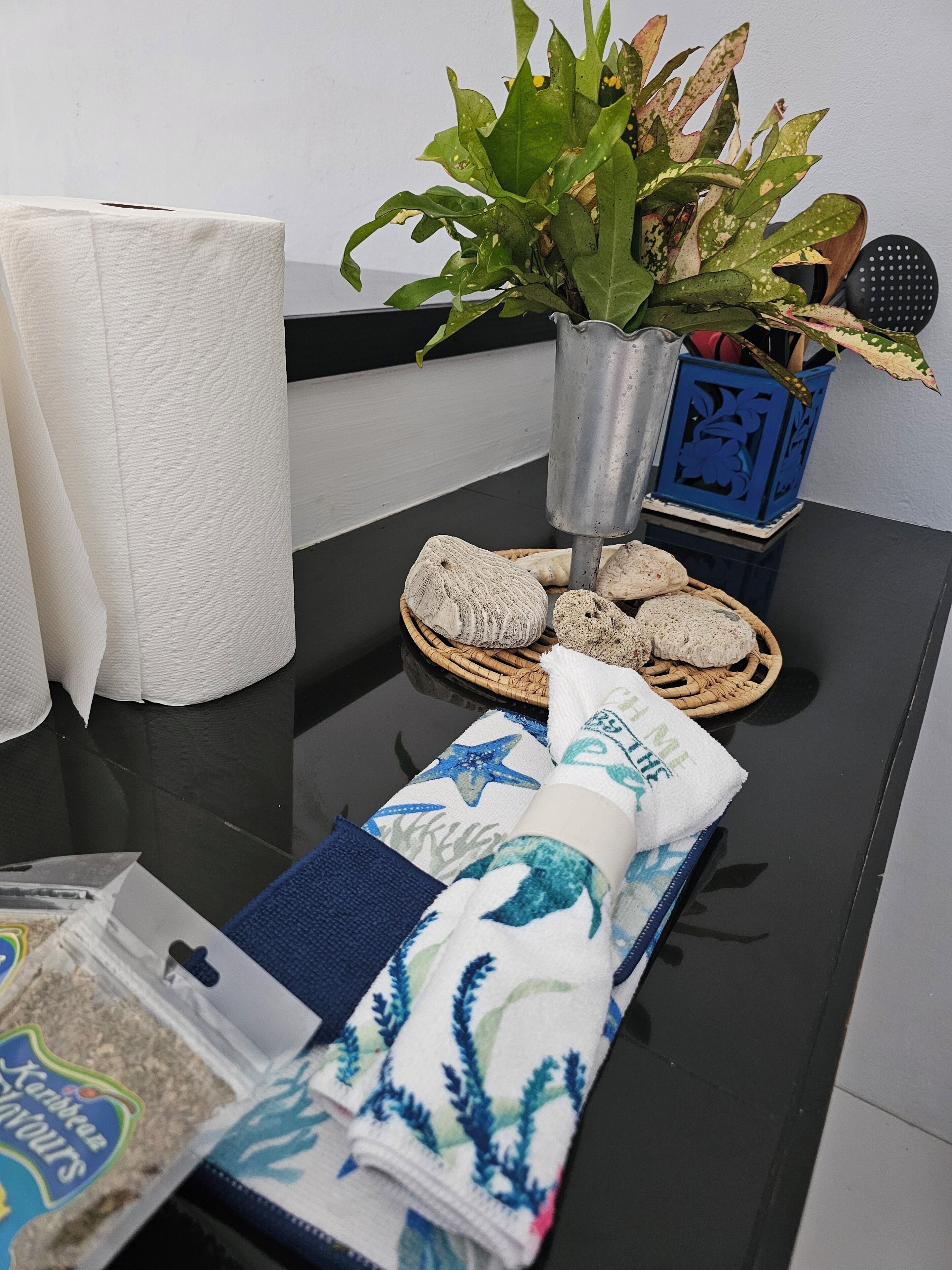 Een tafel met een plant, een broodmand en een opgerolde handdoek.