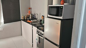 Eine moderne Küche mit einem Edelstahl-Kühlschrank, einer Mikrowelle und einem Backofen.