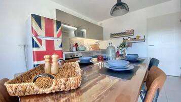 A dining area with a wooden table, blue plates, and a woven basket.