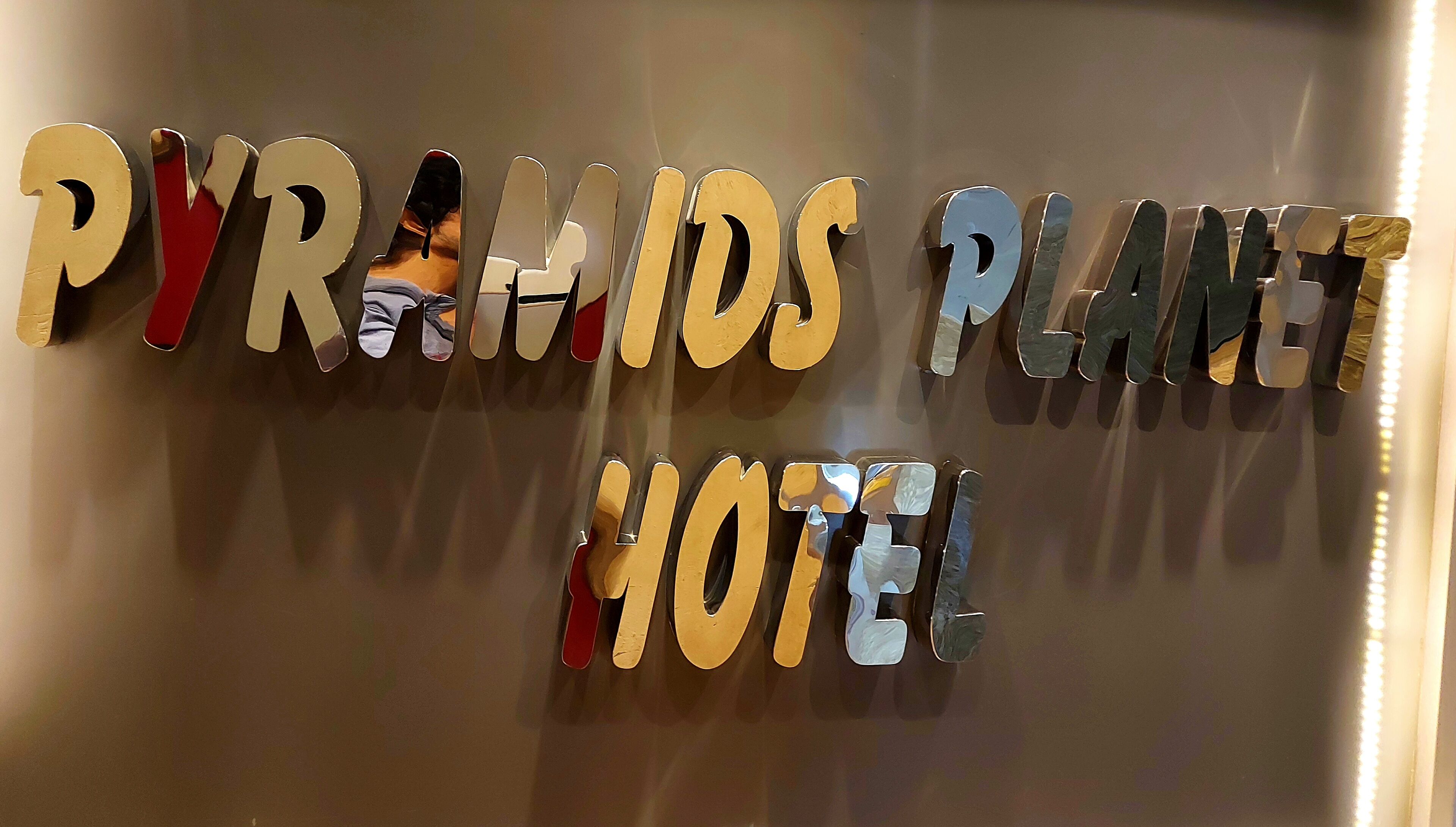 Une enseigne pour l’hôtel Pyramids Planet, avec un design moderne.