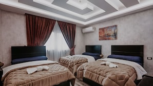 A hotel room with two beds, a large window with curtains, an air conditioning unit, and a painting on the wall. - Pyramids planet hotel (Giza)