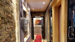 A hallway with a red carpet, stone walls, and recessed lighting. - Pyramids planet hotel (Giza)