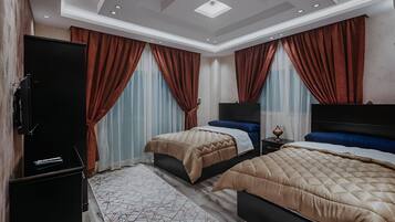 Habitación de hotel con dos camas, un televisor de pantalla plana y un minibar.