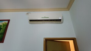 An air conditioning unit mounted on a wall with a wooden trim ceiling. - Hotel O Vj Sweethome Syariah (Mataram)