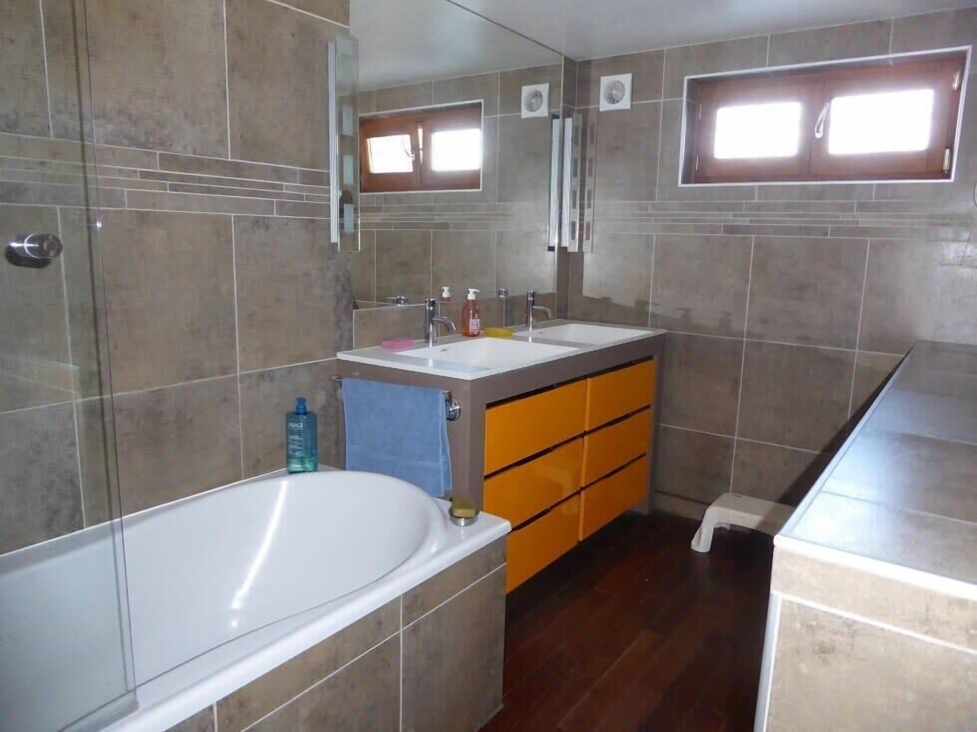 Un baño con bañera, lavabo y espejo.