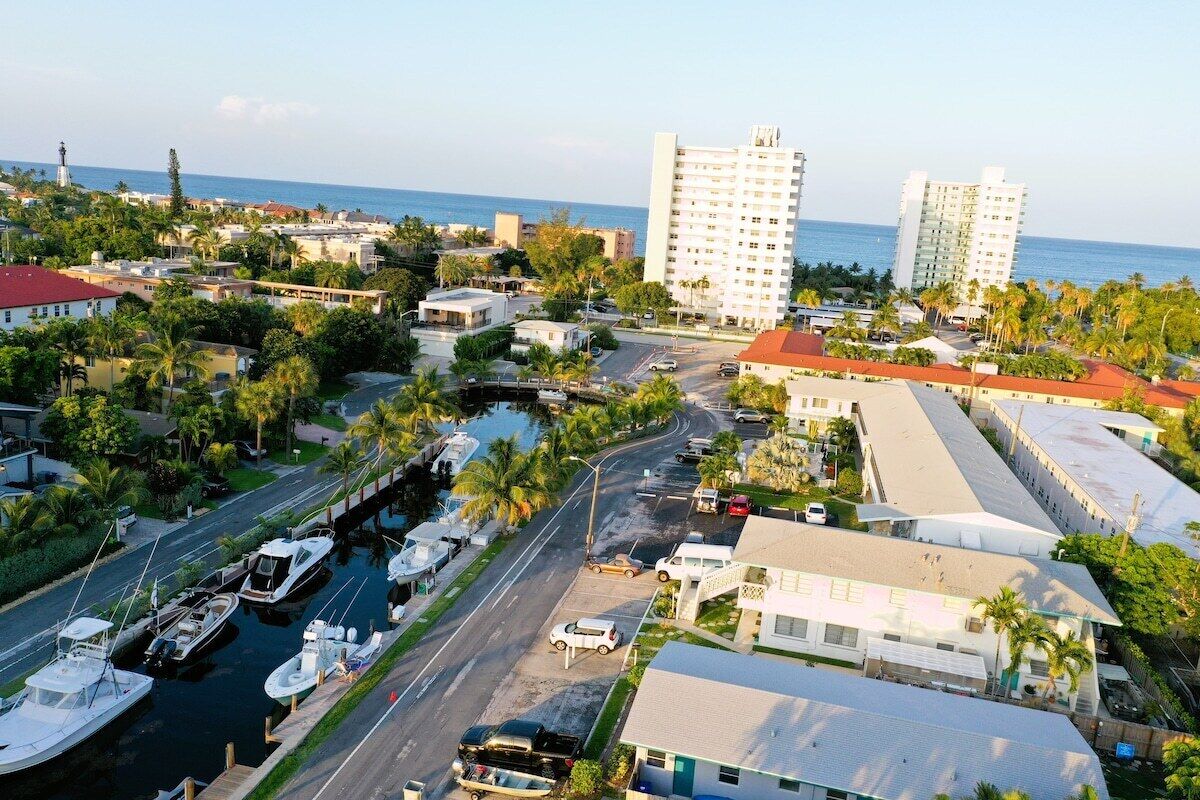 Un pueblo costero con un puerto deportivo, edificios y un faro.