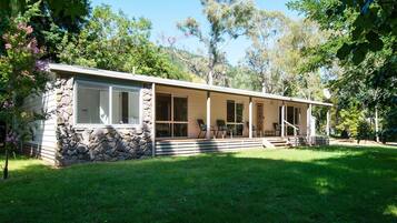 Relax on the covered porch amidst a serene natural setting.