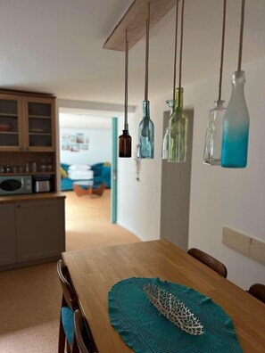 Enjoy meals in this stylish dining area with a wooden table for four, pendant lights, and a decorative centerpiece.