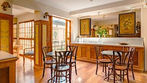 Een ruime keuken met houten kastjes, een marmeren aanrechtblad en een eetgedeelte met houten stoelen.