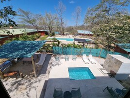 Un área de piscina con múltiples sillas de descanso y una piscina pequeña.