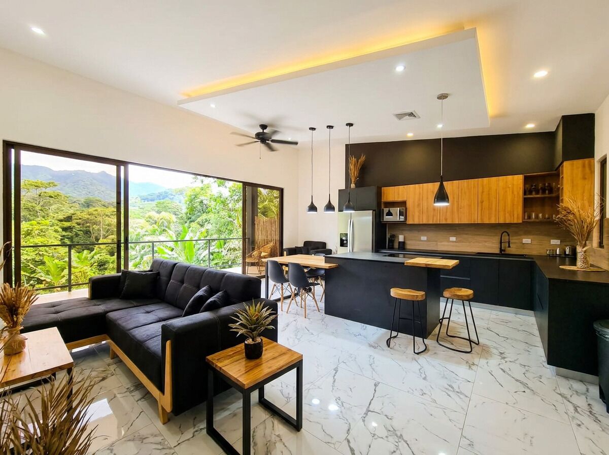 Una cocina moderna con encimera negra, armarios de madera y una isla grande con taburetes de bar.
