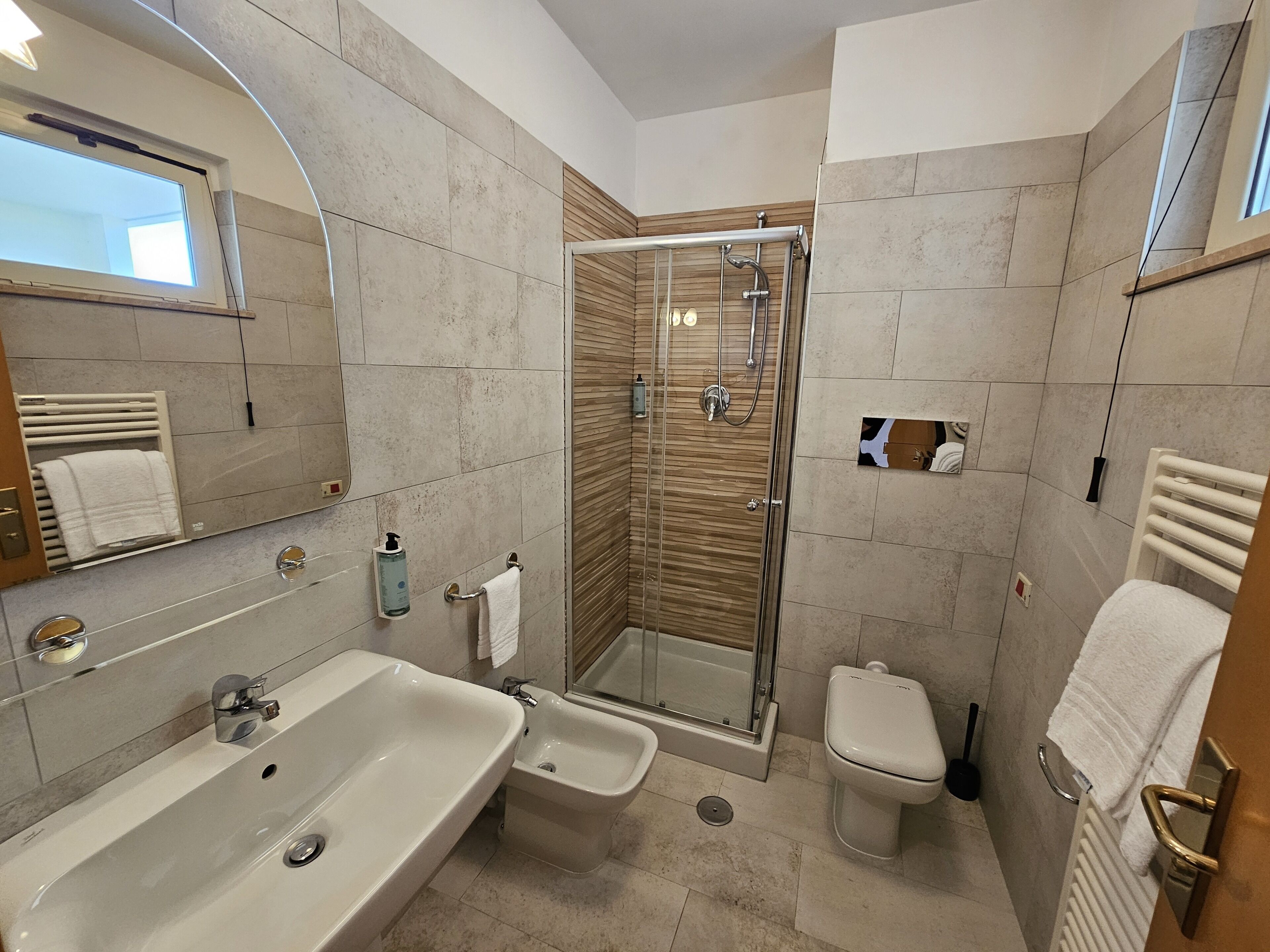 Ein modernes Badezimmer mit einer großen Badewanne, einer Duschkabine, einer Toilette und einem Bidet.