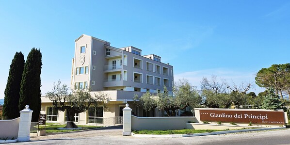 Een meerhoog hotel met een bord waarop staat 'Giardino dei Principi Hotel & Events'.
