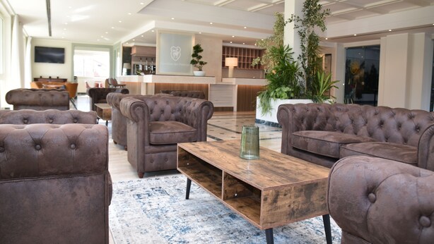 A spacious living area with tufted sofas, a wooden coffee table, and a large potted plant. - Giardino Dei Principi (Citta Sant'Angelo)