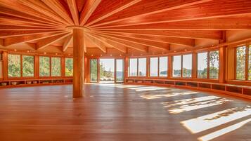 A spacious room with a high ceiling and large windows, allowing natural light to fill the space.