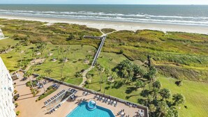Un resort con piscina, lettini e vista sulla spiaggia.