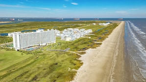 Un hotel costero con varias edificaciones, una playa y un muelle.