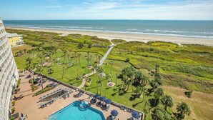 A hotel with a pool, beach view, and a golf course. - 1015 Palm Paradise Beachfront Hideaway (Galveston)