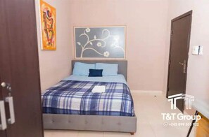 1 dormitorio, escritorio, tabla de planchar con plancha y ropa de cama
