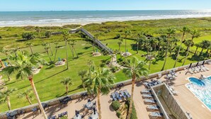 Ein Resort mit Pool, Liegestühlen und Blick auf Strand und Meer.