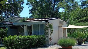 A house with a covered patio, a small garden, and a gravel driveway. - Guest House L'orto di Antonio, surrounded by greenery a few steps from the sea  (Palinuro)