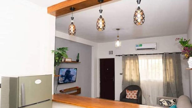 Una sala de estar moderna con una encimera de madera, un televisor e iluminación decorativa.