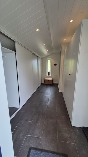 A hallway with a bench, a window, and a door.