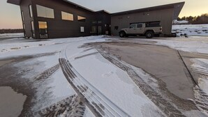 Een modern gebouw met grote ramen en een vrachtwagen ervoor geparkeerd.
