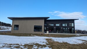 Een modern gebouw met twee verdiepingen, een plat dak en grote ramen.