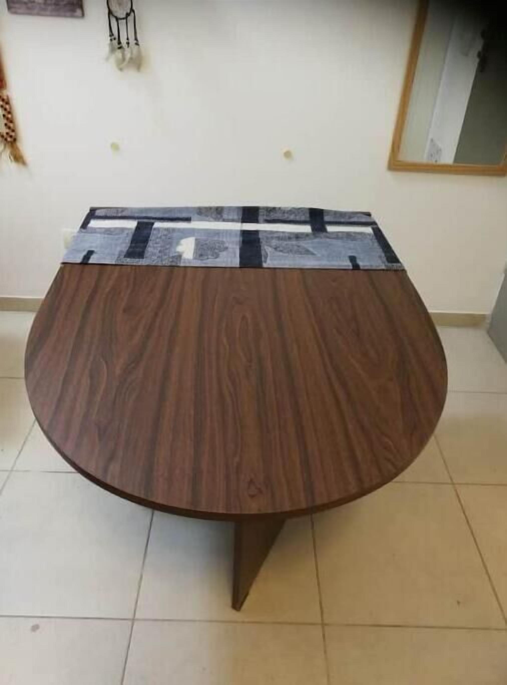 A round wooden table with a black and white patterned tablecloth.
