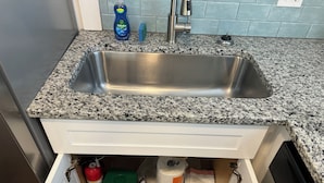 A kitchen with a stainless steel sink, granite countertop, and a white cabinet below. - 1 Mile to Anna Maria Island, 2 bd rm 2 bath 3 Queen beds, sleeps 6 comfortably. (Bradenton)