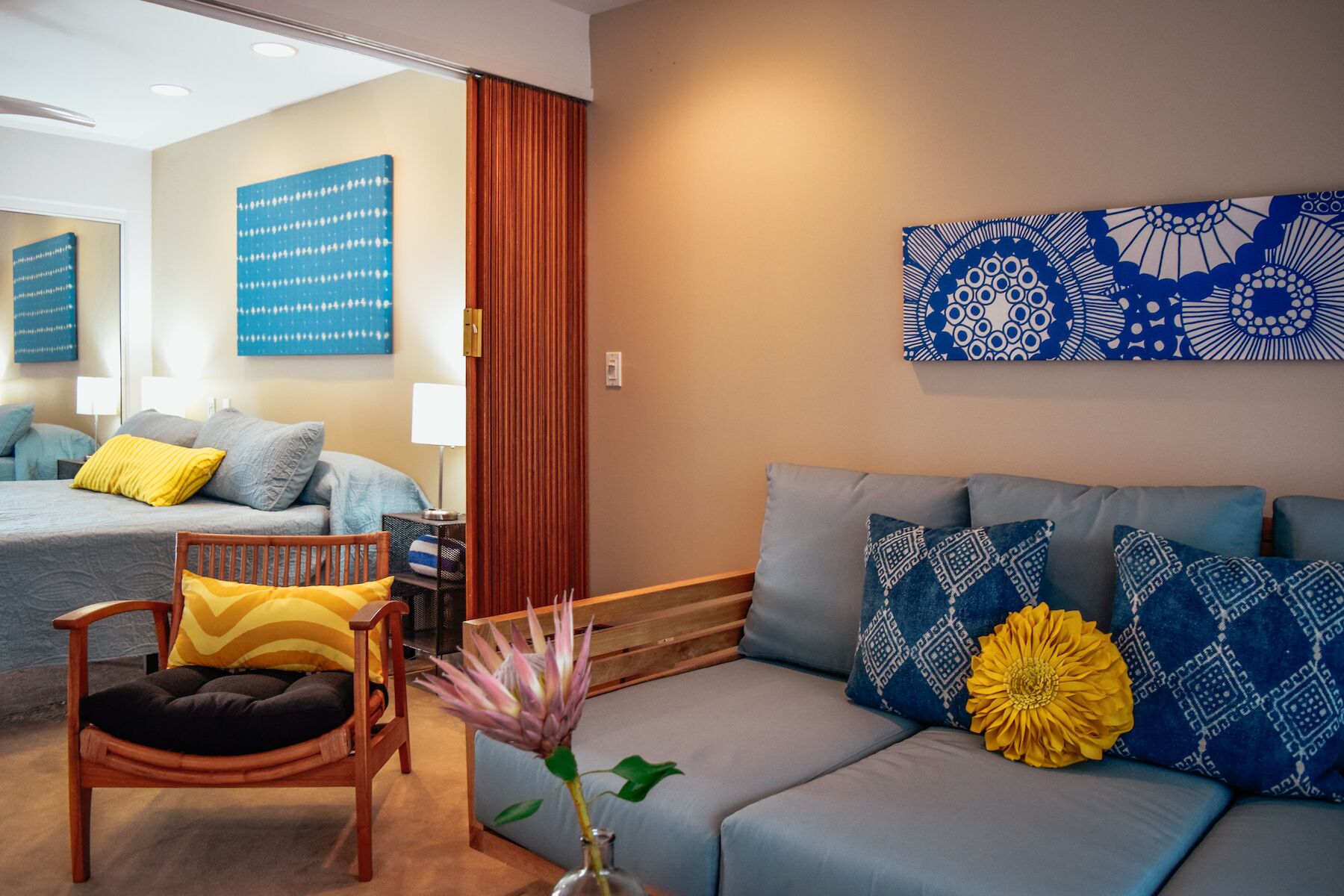 A modern hotel room with a sofa, chair, and a bed.
